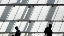 FILE PHOTO: Men walk in the hall outside a Hire Our Heroes job fair targeting unemployed military veterans and sponsored by the Cable Show, a cable television industry trade show in Washington, June 11, 2013. REUTERS/Jonathan Ernst/File Photo