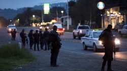 Police officers stand guard as they carry out inspections at a checkpoint after 13 people were killed in battles between rival gangs in two states in central and western Mexico, in Uruapan, in the state of Michoacan, Mexico, September 13, 2017. REUTERS/Alan Ortega