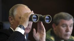 Russian President Vladimir Putin uses a pair of binoculars while watching the Zapad-2017 war games, held by Russian and Belarussian servicemen, with Chief of the General Staff of Russian Armed Forces Valery Gerasimov seen nearby, at a military training ground in the Leningrad region, Russia September 18, 2017.