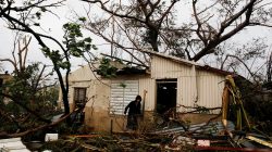 A man looks for valuables in the damaged house of a relative after the area was hit by Hurricane Maria in Guayama, Puerto Rico September 20, 2017.