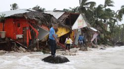 People walk among debris on the seashore in the aftermath of Hurricane Maria in Punta Cana, Dominican Republic, September 21, 2017. REUTERS/Ricardo Rojas