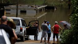 Local residents look at the flooded houses close to the dam of the Guajataca lake. REUTERS/Carlos Garcia Rawlins