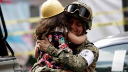 A girl hugs a Mexican marine officer as she offers hugs to people near the site of a collapsed building after an earthquake, in Mexico City.