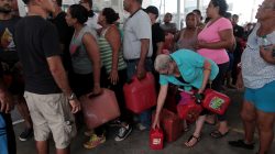 FILE PHOTO: People line up to buy gasoline at a gas station after the area was hit by Hurricane Maria, in San Juan, Puerto Rico September 22, 2017. Picture taken September 22, 2017. REUTERS/Alvin Baez/File Photo