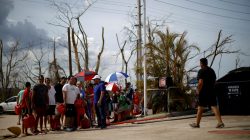 FILE PHOTO: People queue to fill container with gasoline in a gas station after the area was hit by Hurricane Maria in Toa Baja, Puerto Rico September 24, 2017. REUTERS/Carlos Garcia Rawlins/File Photo