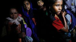 Women carry children through the water as hundreds of Rohingya refugees arrive under the cover of darkness by wooden boats from Myanmar to the shore of Shah Porir Dwip, in Teknaf, near Cox's Bazar in Bangladesh, September 27, 2017. Picture taken September 27, 2017. REUTERS/Damir Sagolj