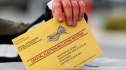 FILE PHOTO - A poll worker places a mail-in ballot into a voting box as voters drop off their ballot in the U.S. presidential primary election in San Diego, California, United States, June 7, 2016. REUTERS/Mike Blake/File Photo