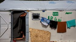 FILE PHOTO: A migrant from Iran stands at the entrance of his tent at the Souda municipality-run camp for refugees and migrants on the island of Chios, Greece, March 16, 2017. REUTERS/Alkis Konstantinidis