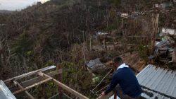 A local resident sits on the roof of his home that was damaged by Hurricane Maria in Guaynabo, Puerto Rico, October 2, 2017. REUTERS/Alvin Baez