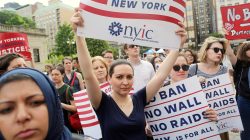 FILE PHOTO - Protesters hold signs against U.S. President Donald Trump's limited travel ban, approved by the U.S. Supreme Court, in New York City, U.S. on June 29, 2017. REUTERS/Joe Penney/File Photo