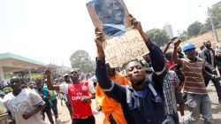 A supporter of Kenyan opposition National Super Alliance (NASA) coalition, carries a banner depicting Kenyan opposition leader Raila Odinga during a protest along a street in Nairobi, Kenya, October 11, 2017. REUTERS/Baz Ratner