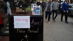 Pedestrians pass a sign advertising a sale and a job opening at a shop on Newbury Street in Boston, Massachusetts, U.S., October 11, 2017. REUTERS/Brian Snyder