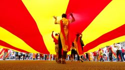 People walk under a huge Catalan flag during Spain's National Day in Barcelona. REUTERS/Gonzalo Fuentes