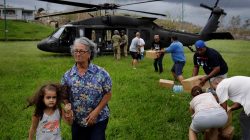 A woman and child walk away as soldiers in a UH-60 Blackhawk helicopter from the First Armored Division's Combat Aviation Brigade deliver food and water during recovery efforts following Hurricane Maria in Verde de Comerio, Puerto Rico, October 7, 2017. REUTERS/Lucas JacksonA woman and child walk away as soldiers in a UH-60 Blackhawk helicopter from the First Armored Division's Combat Aviation Brigade deliver food and water during recovery efforts following Hurricane Maria in Verde de Comerio, Puerto Rico, October 7, 2017. REUTERS/Lucas Jackson