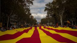 People walk with a huge Catalan flag during Spain's National Day in Barcelona.