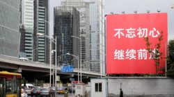 A security guard walks under a banner reading "Stay true to the mission, continue to move foward" in Beijing's central business area, as the capital prepares for the 19th National Congress of the Communist Party of China, October 14, 2017. REUTERS/Jason Lee