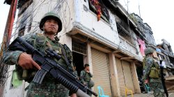 FILE PHOTO: Government soldiers stand guard in front of damaged building and houses in Sultan Omar Dianalan boulevard at Mapandi district in Marawi city, southern Philippines September 13, 2017. REUTERS/Romeo Ranoco