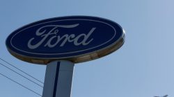 FILE PHOTO: An airplane flies above a Ford logo in Colma, California, U.S., October 3, 2017. REUTERS/Stephen Lam