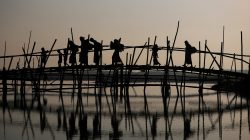 Rohingya refugees cross a bamboo bridge as they arrive at a port after crossing from Myanmar, in Teknaf, Bangladesh, October 25, 2017. REUTERS/Hannah McKay