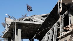 A flag of Islamic State militants is pictured above a destroyed house near the Clock Square in Raqqa, Syria October 18, 2017. Picture taken October 18, 2017. REUTERS/Erik De Castro