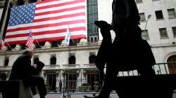 Morning commuters are seen outside the New York Stock Exchange, July 30, 2012.