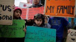 A girl holds a placard reading, "where is my Mother, where is my Father", as refugees protest, some announcing a hunger strike, as they seek reunification with family members in Germany, near the parliament building in Athens, Greece, November 1, 2017.