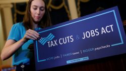 A congressional aide places a placard on a podium for the House Republican's legislation to overhaul the tax code on Capitol Hill.