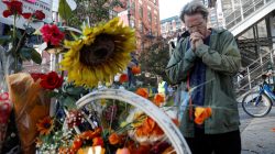 A man prays after laying flowers at an existing roadside memorial, a ghost bike, that is now used to remember the victims of the Tuesday's attack alongside a bike path at Chambers Street in New York City, in New York, U.S., November 2, 2017.