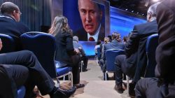 Journalists watch Russia's President Vladimir Putin on a big screen during his annual news conference in Moscow, December 20, 2012.