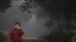 A man covers his face with a handkerchief as he walks ina park on a smoggy morning in New Delhi, India, November 9, 2017.
