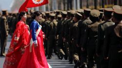 Women wearing traditional clothes walk past North Korean soldiers after an opening ceremony for a newly constructed residential complex in Ryomyong street in Pyongyang, North Korea April 13, 2017.