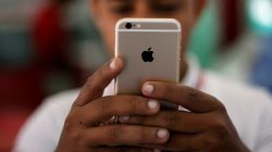 A salesman checks a customer's iPhone at a mobile phone store in New Delhi, India, July 27, 2016.