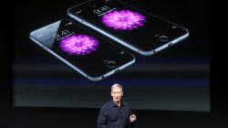 Apple CEO Tim Cook stands in front of a screen displaying the IPhone 6 during a presentation at Apple headquarters in Cupertino, California October 16, 2014.