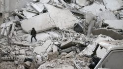 A boy walks on rubble of damaged buildings after an airstrike on the Eastern Ghouta town of Misraba, Syria, January 4, 2018.