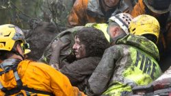 Emergency personnel carry a woman rescued from a collapsed house after a mudslide in Montecito, California, U.S. January 9, 2018.