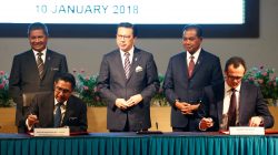 Civil Aviation Malaysia's Director General Azharuddin Abdul Rahman and Ocean Infinity's CEO Oliver Plunkett sign documents, witnessed by Malaysia's Transport Minister Liow Tiong Lai, during the MH370 search operations signing ceremony between Malaysia's government and Ocean Infinity, in Putrajaya, Malaysia January 10,