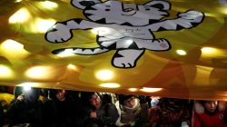 Women watch the Olympic torch relay under a giant banner depicting the 2018 PyeongChang Winter Olympics mascot Soohorang, in Seoul, South Korea, January 13, 2018.