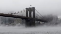 The Brooklyn Bridge is seen partially in fog from in front of the Manhattan skyline in Brooklyn, New York, U.S., January 12, 2018.