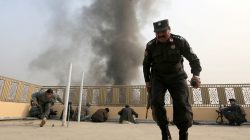 Afghan police officers take position during a blast and gun fire in Jalalabad, Afghanistan January 24,