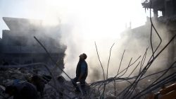 A man stands on rubble of damaged buildings after an airstrike in the besieged town of Hamoria, Eastern Ghouta, in Damascus, Syria Janauary 9, 2018.
