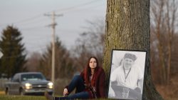Taylor Wiggington sits with a photo of her father, Doug Wiggington, in the area where he was shocked by a Taser on May 12, 2017, in Greenfield, Indiana, U.S., December 21, 2017.