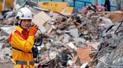 A rescuer speaks on the radio as he searches for survivors at collapsed building after an earthquake hit Hualien, Taiwan February 8, 2018.