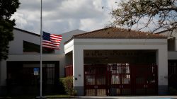 A flag flies at half mast next to the entrance of the Marjory Stoneman Douglas High School, after the police security perimeter was removed. REUTERS/Carlos Garcia Rawlins