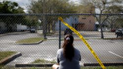 A woman mourns in front of the fence of the Marjory Stoneman Douglas High School. REUTERS/Carlos Garcia Rawlins