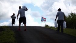 A woman waits as municipal workers distribute water and ice provided by the U.S. Federal Emergency Management Agency (FEMA), after Hurricane Maria hit the island in September 2017, in Comerio, Puerto Rico January 31, 2018. Picture taken January 31, 2018. REUTERS/Alvin Baez