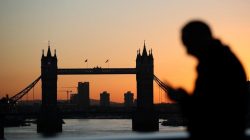 A man walks across London Bridge as the sun rises behind Tower Bridge in London, Britain, January 19, 2018. REUTERS/Hannah McKay