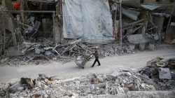 A man pushes a cart past damaged buildings at the besieged town of Douma, Eastern Ghouta, Damascus, Syria March 5, 2018. REUTERS/Bassam Khabieh