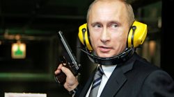 FILE PHOTO: Russian President Vladimir Putin stands with a gun at a shooting gallery of the new GRU military intelligence headquarters building as he visits it in Moscow November 8, 2006.