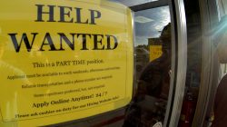 FILE PHOTO: A help wanted sign is posted on the door of a gas station in Encinitas California