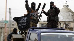FILE PHOTO: Members of al Qaeda's Nusra Front gesture as they drive in a convoy touring villages, which they said they have seized control of from Syrian rebel factions, in the southern countryside of Idlib, Syria December 2, 2014. REUTERS/Khalil Ashawi/File Photo